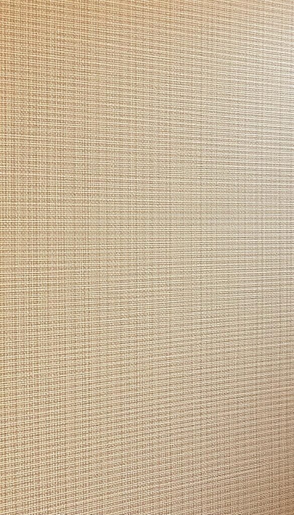 Grasscloth Wallpaper Natural Texture - a lush, finely woven surface with delicate striations and a warm, earthy tone, bathed in soft, diffused lighting that highlights the subtle variations in the material. The texture is crisp and distinct, inviting the viewer to reach out and feel the intricate fibrous pattern. The wallpaper extends across the frame, filling the scene with a sense of tranquil sophistication, perfectly complementing a modern luxury living room space. Captured at a medium angle to showcase the expansive coverage and natural elegance of this high-quality grasscloth wall covering.