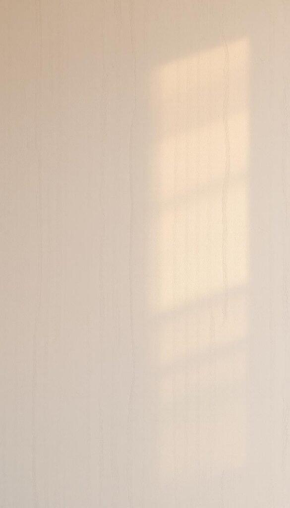 Textured beige walls with a delicate lime wash finish, creating a soft, hazy glow. Subtle ridges and grooves add depth and character, reflecting the warm, natural light filtering through large windows. The matte surface has a velvety, tactile quality, evoking a sense of tranquility and sophistication. Captured at a medium angle, the walls fill the frame, drawing the eye towards the intricate, mottled patterns. An understated, calming atmosphere pervades the scene, setting the stage for a refined, neutral-toned living space.