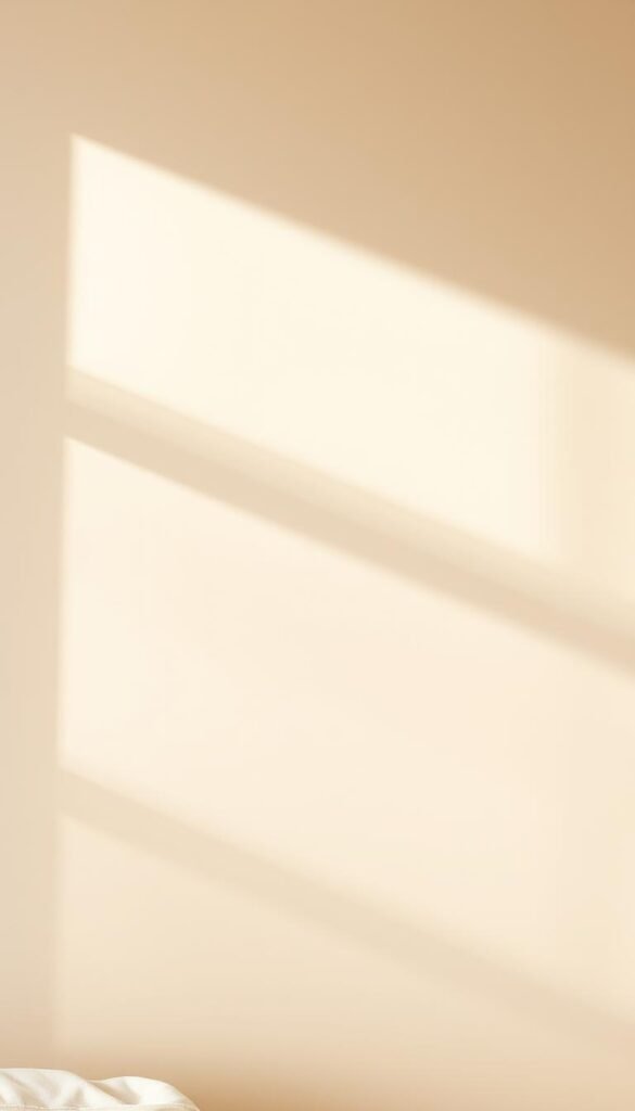 A tranquil, serene beige wall in warm natural light, showcasing a soft, inviting color palette with subtle undertones of cream, champagne, and muted gold. The surface has a smooth, eggshell-like finish, creating a calming, refined ambiance. The lighting casts gentle shadows, accentuating the depth and texture of the wall, while maintaining an overall balanced and harmonious atmosphere. The camera angle captures the wall in a way that highlights its role as the foundation for a cozy, neutral bedroom setting, setting the stage for thoughtfully curated decor accessories.