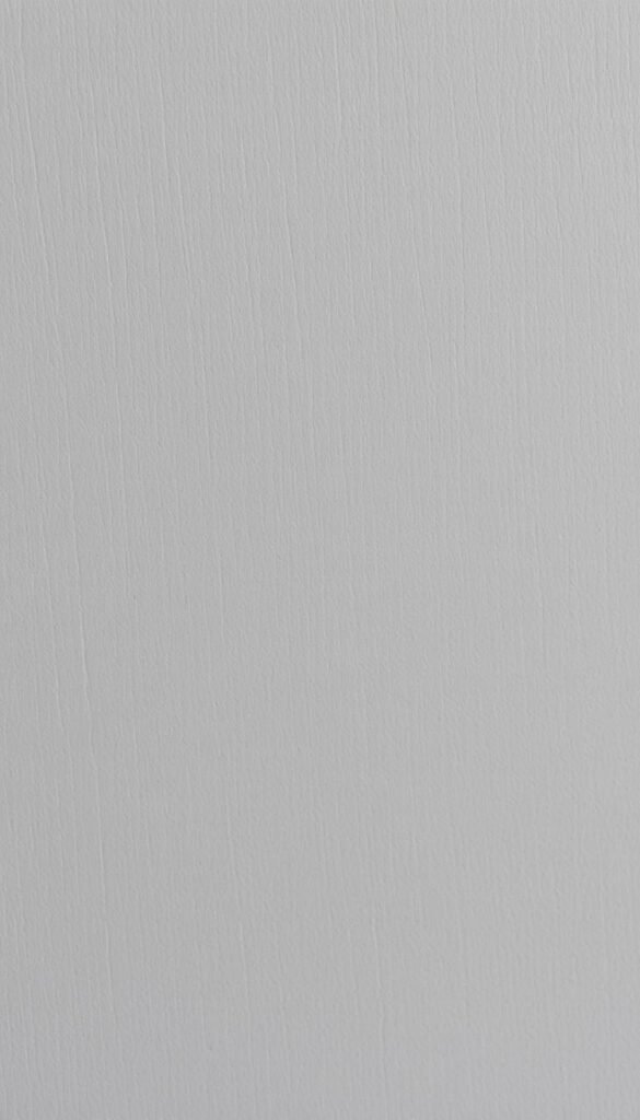 A detailed close-up of soft, muted grey paint with subtle warm and cool undertones. The surface texture is smooth and velvety, with a slight sheen that catches the light. The paint appears to have been carefully applied, with no visible brush strokes or imperfections. The lighting is soft and diffused, creating a calming, atmospheric feel that showcases the depth and nuance of the grey hue. The image is framed tightly, filling the frame and drawing the viewer's attention to the rich, complex nature of the paint color.