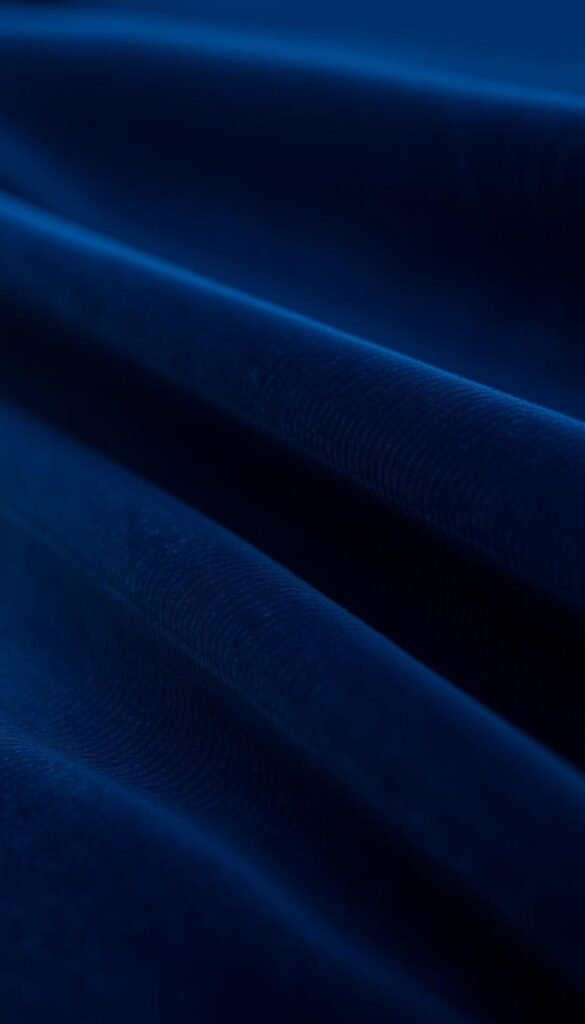 A finely crafted, premium velvet fabric in a lush, midnight blue hue. Closer inspection reveals the intricate weave, with each thread meticulously interlaced to create a sumptuous, velvety texture. The fabric appears to have a slight sheen, reflecting the warm, directional lighting that bathes the scene. The camera focuses in on the detailed construction, capturing the nuanced variations in the nap and the subtle shading that gives the velvet its depth and richness. The overall mood is one of elegance, luxury, and impeccable craftsmanship, perfectly suited to adorn the windows of a sophisticated, high-end bedroom.